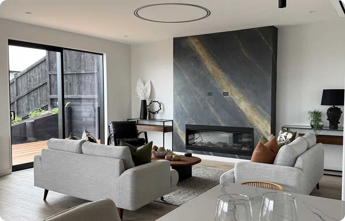 Modern living room featuring stylish furniture, a sleek fireplace, and large windows, showcasing our design Services.
